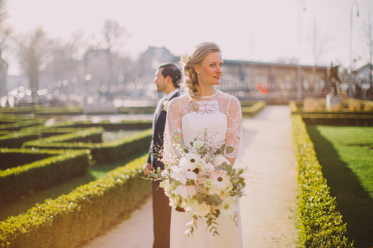 Wedding day photo of bride and groom in a manicured Amsterdam garden. Photograph captured by Eliska at Khiria Photography
